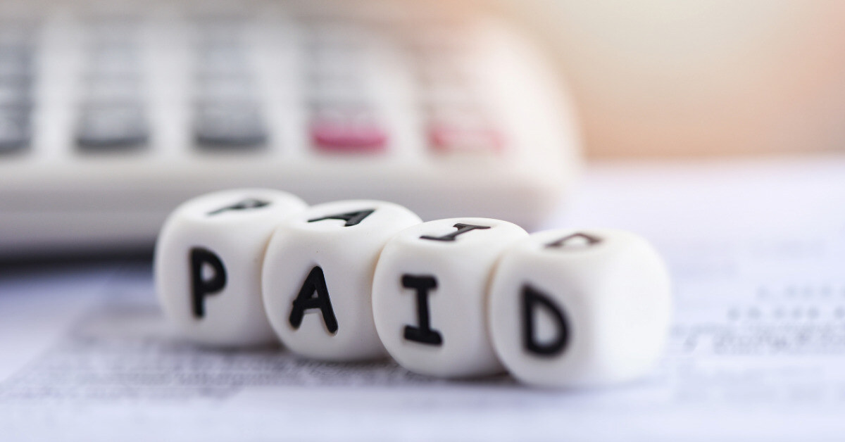 Paid words and calculator on invoice bill paper for time paid payment at office business finances