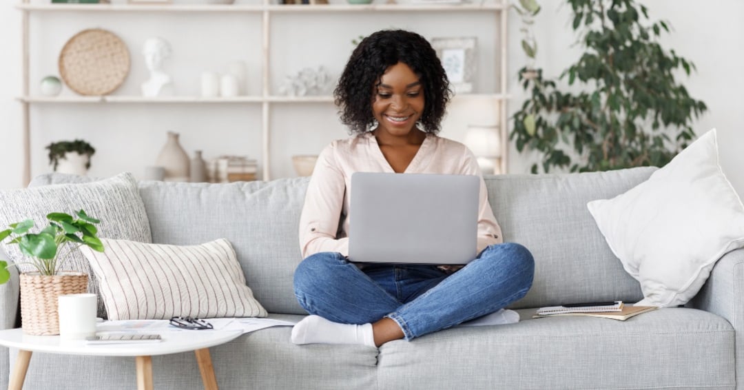 woman working on laptop while sitting on a couch