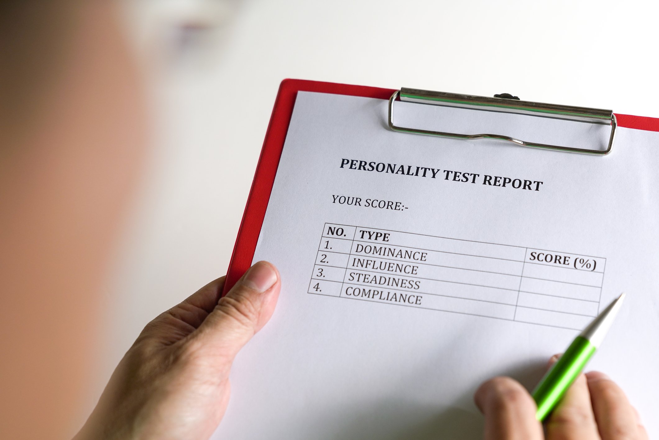 a person holds a clipboard with a personality test report on it