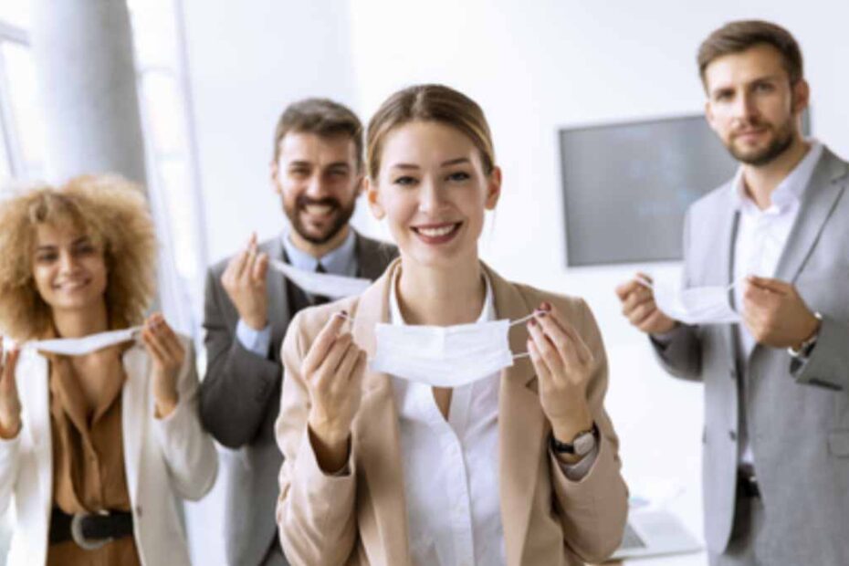 group of workers smiling and holding their masks away from their face