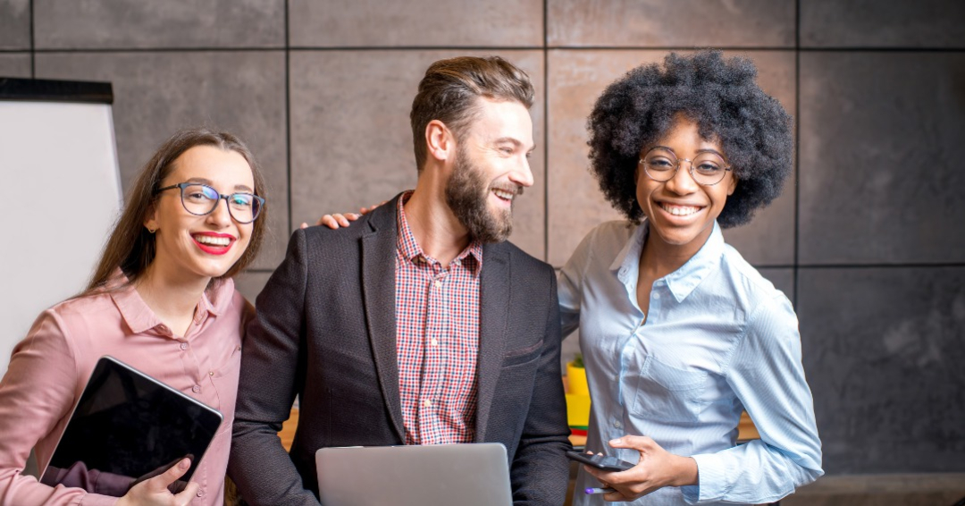 Portrait of three happy multi ethnic coworkers together at the office