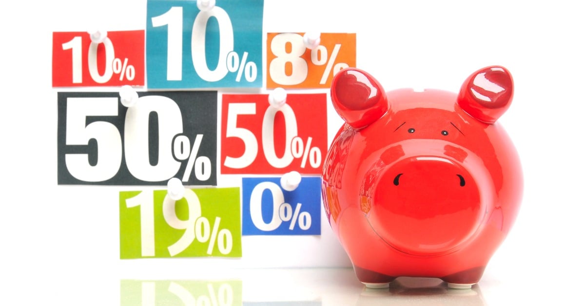 Saving money - red piggy bank with multicolored newspaper percentage adverts