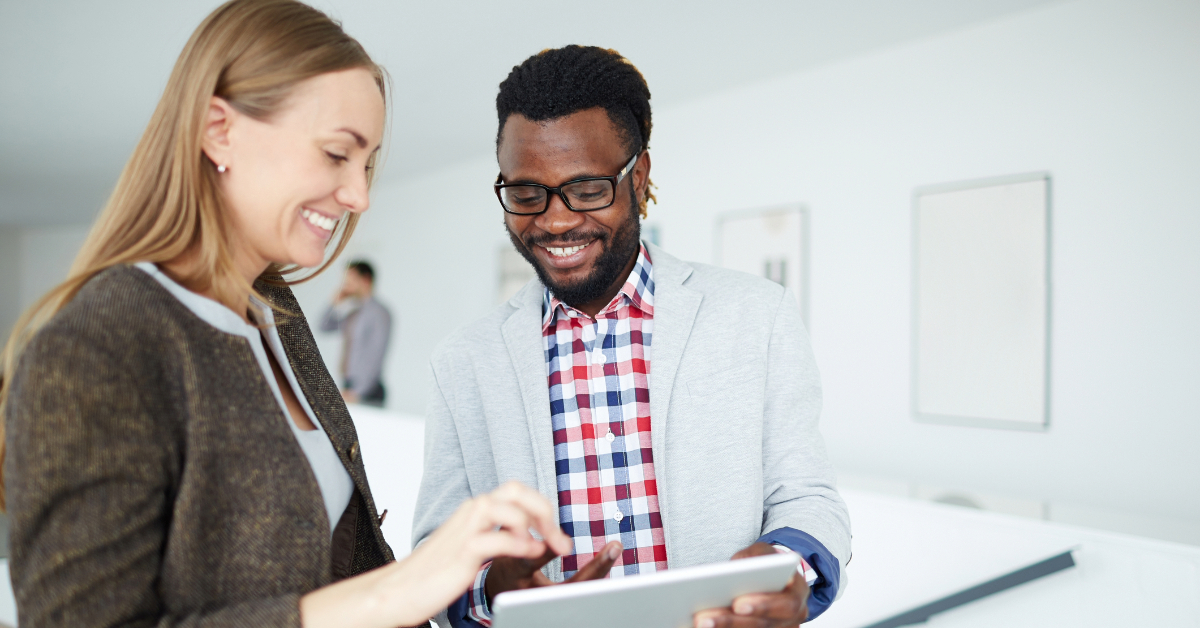 Two employees discussing data in touchpad