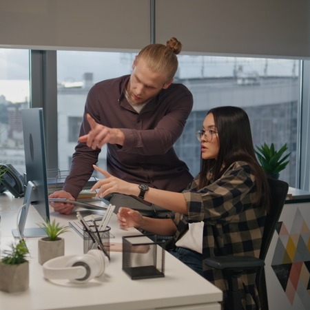 team members collaborate and point at a shared screen