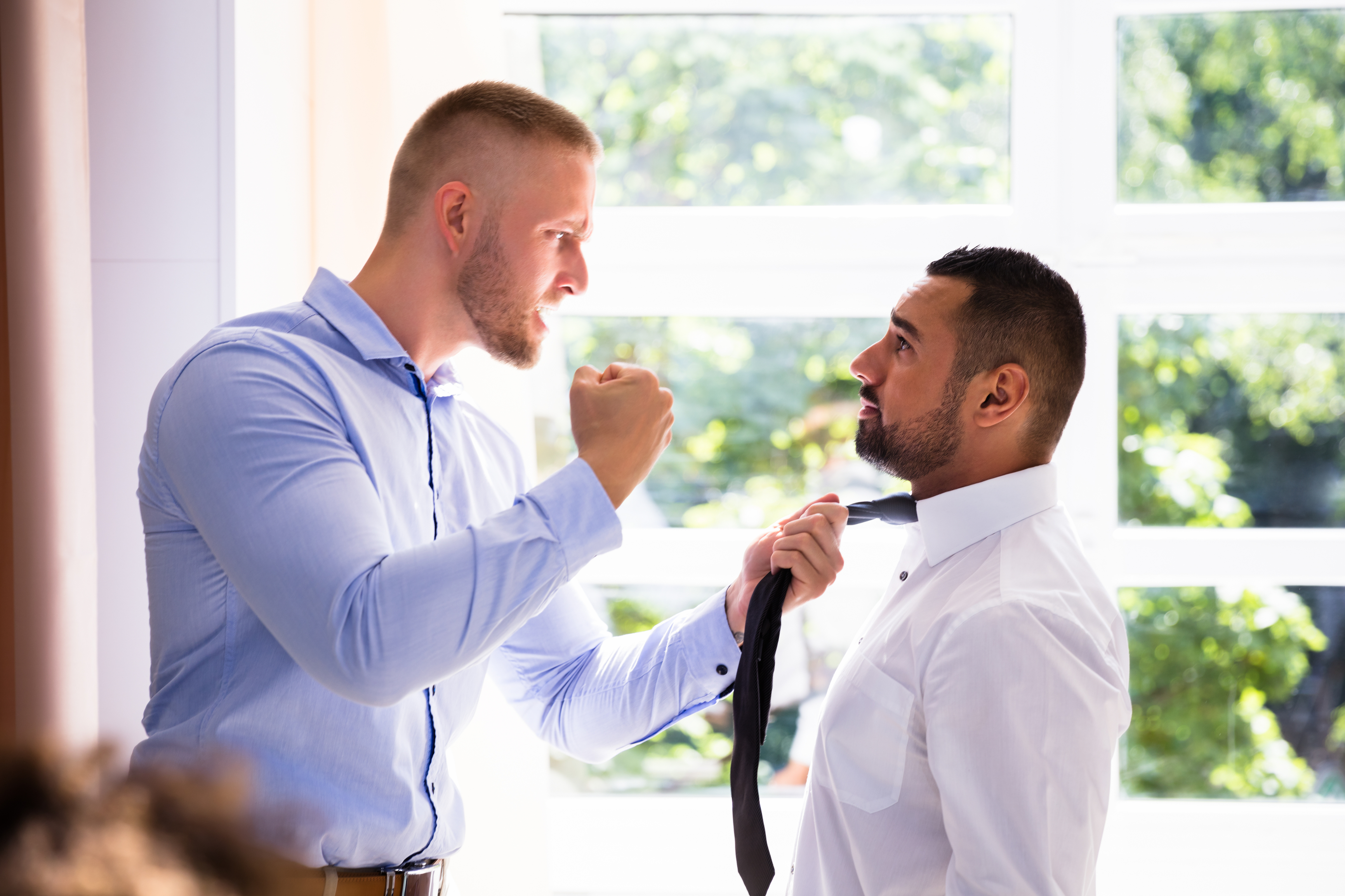 Man threatening another man, displaying workplace violence