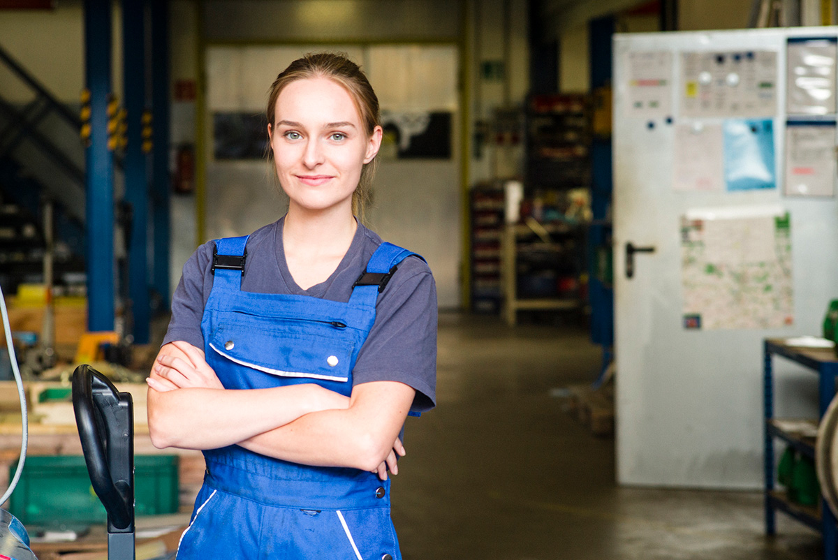 GettyImages-1028767230-Portrait of a smiling young female trainee in metal industry, arms crossed