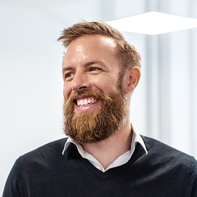 GettyImages-1180182861-Confident bearded businessman looking away while standing by bulletin board in creative office