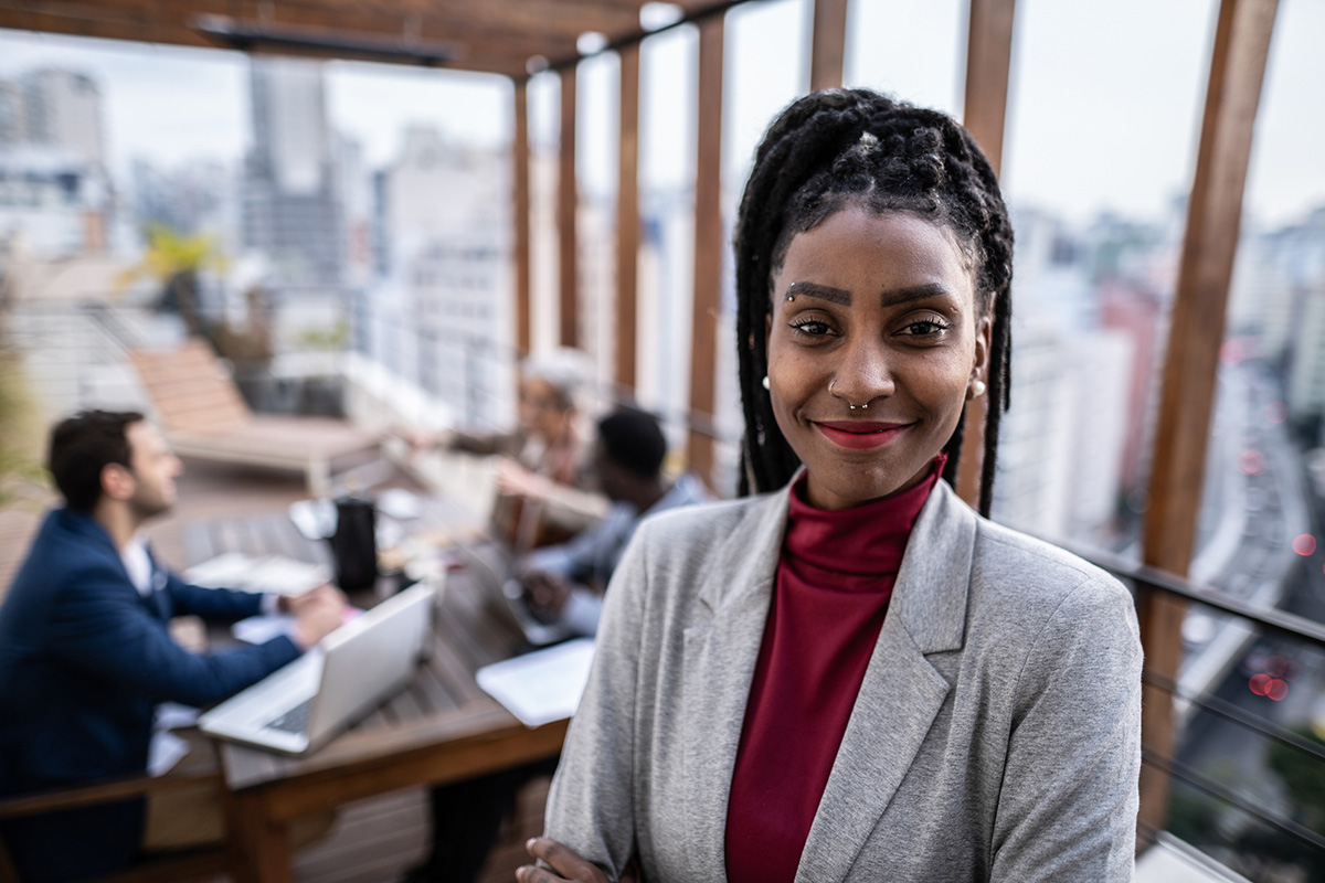 GettyImages-1334323139-Portrait of a confident businesswoman outdoors - team meeting on the background