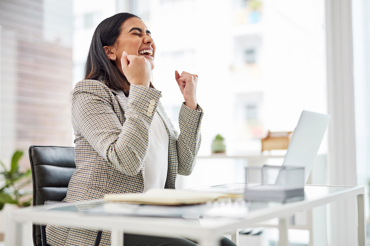 GettyImages-1354842018-Shot of a young businesswoman cheering while working on a laptop in an office