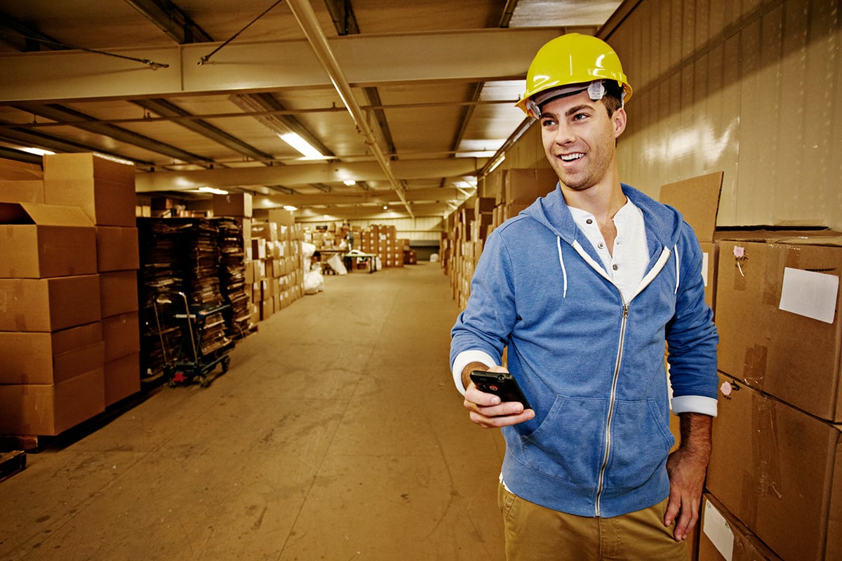 GettyImages-169261758-Caucasian worker using cell phone in warehouse
