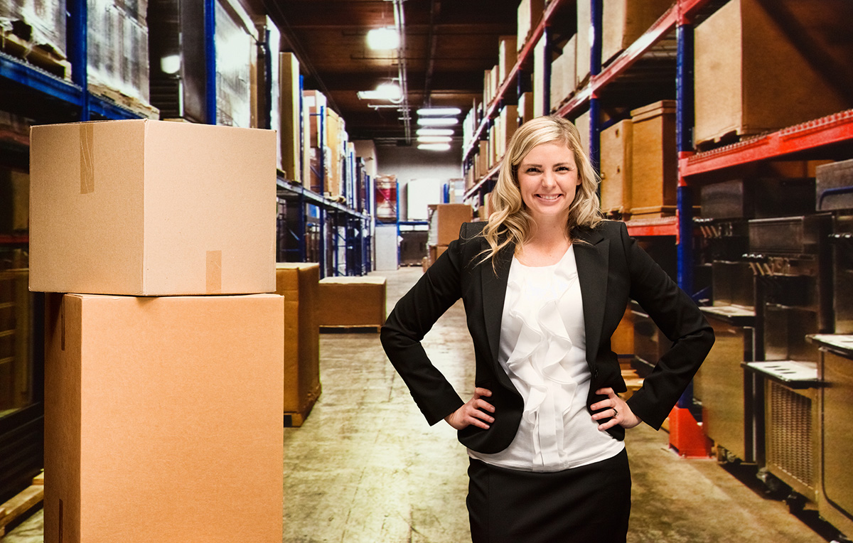 GettyImages-542825452-Smiling businesswoman standing in warehouse
